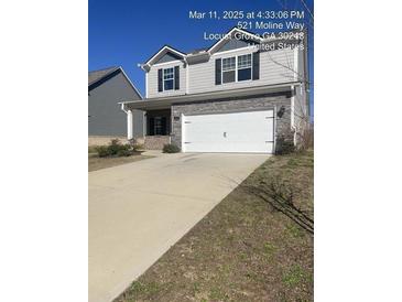 Charming two-story home featuring a two-car garage and well-manicured lawn at 521 Moline Way, Locust Grove, GA 30248