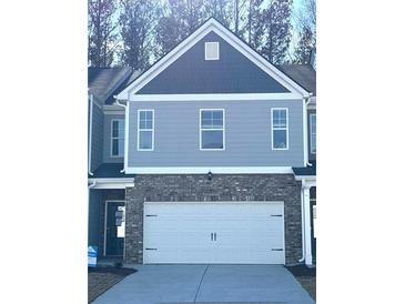 Two-story townhome with gray siding, brick accents, and a two-car garage at 133 Stanchion Dr, Union City, GA 30291