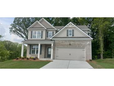Charming two-story home with brick facade, inviting entrance, attached garage, and well-manicured lawn at 6025 Spring Way, Stonecrest, GA 30038