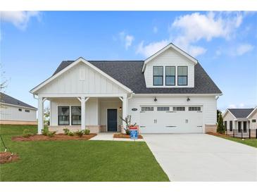 Charming two-story home featuring a covered porch and a two-car garage in a suburban setting at 5225 Maggie Mae Ln, Cumming, GA 30028