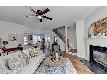 Bright living room featuring hardwood floors, fireplace, modern furniture, and open floor plan to kitchen at 3676 Chattahoochee Summit Dr, Atlanta, GA 30339
