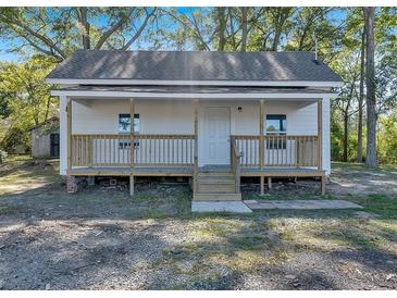 Charming white cottage with a front porch and landscaped yard at 5361 N Main St, Acworth, GA 30101