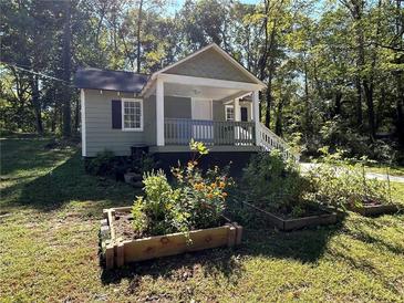 Charming home featuring a cozy front porch and lovely garden boxes in the yard at 3380 Lake Valley Nw Rd, Atlanta, GA 30331