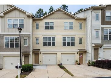 Charming townhome featuring an attached garage, neutral siding, and well maintained landscaping at 1801 Liberty Nw Pkwy, Atlanta, GA 30318