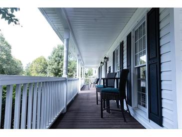 Inviting covered front porch with dark wood flooring and chairs for relaxing outdoors at 295 Whitby Dr, Douglasville, GA 30134