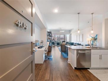 Bright open-concept living space boasts a modern kitchen and dining area with hardwood floors at 1100 Howell Mill Rd # 404, Atlanta, GA 30318