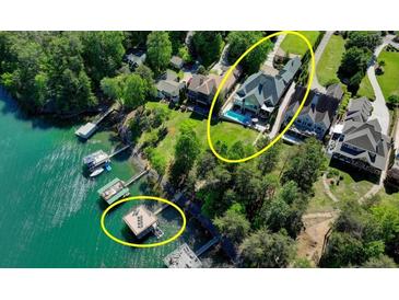 An aerial view showcases the expansive waterfront property with a pool and private dock at 6308 Woodlake Dr, Buford, GA 30518