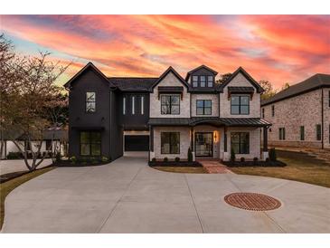 Beautiful two-story home featuring a black and white exterior, complemented by an expansive driveway and manicured landscaping at 159 Shadburn Ferry Rd, Buford, GA 30518