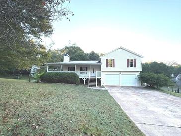 Charming home featuring a covered porch, two-car garage, and well-maintained landscaping at 413 Kenny Ln, Temple, GA 30179