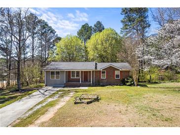 Charming single-story home features a mix of brick and siding, complemented by a well-maintained front lawn at 2420 Green Rd, Loganville, GA 30052