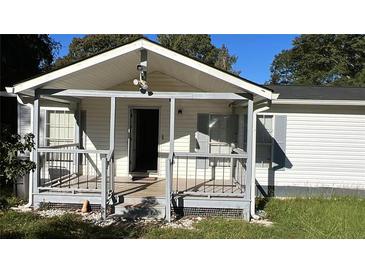 Quaint home featuring a covered front porch with gray railing, offering a welcoming entrance at 698 Rocky Plains Rd, Covington, GA 30016
