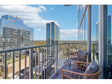 Stunning balcony view with seating, overlooking the city skyline and lush greenery at 860 Peachtree Ne St # 1903, Atlanta, GA 30308