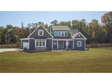 Beautiful two-story home featuring a well-manicured lawn, a blue exterior, and a charming front porch at 255 Old Town Rd, Dacula, GA 30019