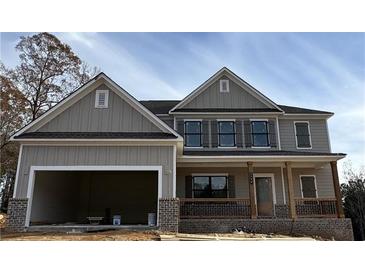Two story house with neutral colored siding, gray shutters and brick foundation with attached two car garage at 1176 Red Oak Blvd, Loganville, GA 30052