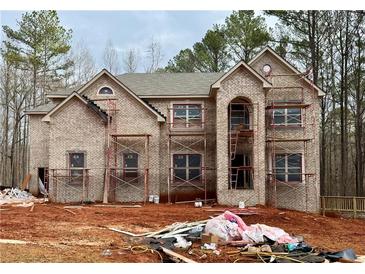 Spacious two-story brick house with a classic design under construction and surrounded by trees at 5400 Deer Run Dr, Conyers, GA 30094