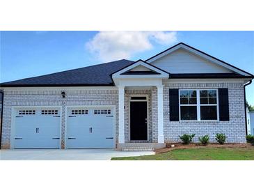 Charming, new construction home featuring a brick facade, a two-car garage, and a welcoming entryway at 130 Oakchase Park Ln, Hampton, GA 30228