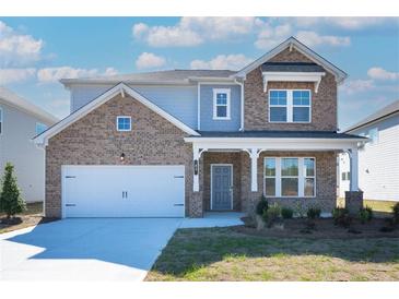 Charming two-story home featuring brick facade, a two-car garage, and a welcoming front porch at 93 Sheryl Way, Loganville, GA 30052