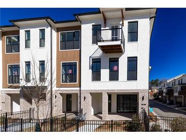 Stylish townhome features modern design, brick accents, a balcony, and well-maintained landscaping at 332 Olmstead Way # 38, Alpharetta, GA 30022