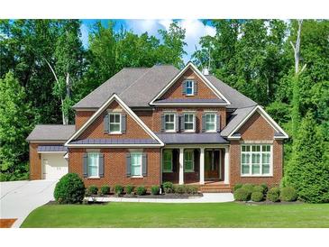 Beautiful brick home with a well-manicured lawn and lush green trees providing ample shade at 2423 Rosapenna Nw Ln, Kennesaw, GA 30152