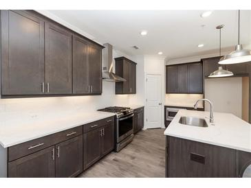 Modern kitchen boasts stainless steel appliances, white countertops, and dark wood cabinets at 348 Olmstead Way # 30, Alpharetta, GA 30022