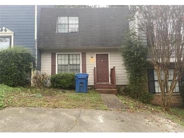 Charming two-story home featuring a cozy front porch and a well-maintained, compact front yard at 300 Flagstone Way, Austell, GA 30168