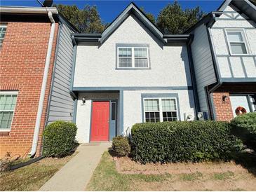 Charming townhome with a stucco facade, tidy landscaping, and a vibrant red front door at 3589 Main Station Sw Dr, Marietta, GA 30008