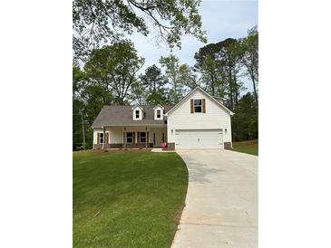 Charming home featuring a manicured lawn, a two car garage and decorative window shutters at 90 Hammock Dr, Covington, GA 30016