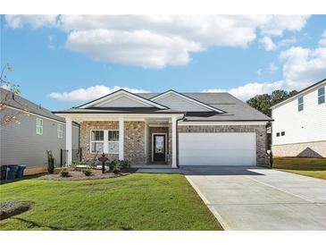 Charming brick home featuring a two-car garage, well-manicured lawn, and welcoming front porch at 1638 High Falls Ln, Grayson, GA 30017