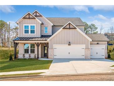 Charming two-story home featuring a three-car garage, brick accents, and a well-manicured lawn at 735 Crossroad Sw Ct, Powder Springs, GA 30127