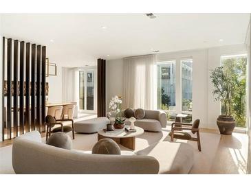 Bright living room with floor to ceiling windows, modern furniture, and neutral color palette at 1301 Peachtree St # 4L, Atlanta, GA 30309