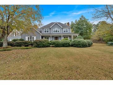 Charming gray two-story home with a welcoming front porch and lush, landscaped front yard at 36 Latimer Nw Ln, Cartersville, GA 30121