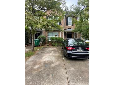 Brick townhouse with a driveway and landscaping at 2621 Parrish Ct, Lithonia, GA 30038