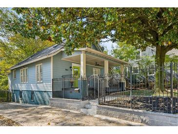 Charming home with a covered front porch, a well-manicured yard, and a secure black metal fence at 701 Glenwood Se Ave, Atlanta, GA 30312