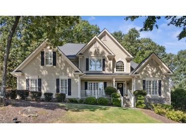 Charming home featuring manicured landscaping, a welcoming porch, and a classic design with a mix of materials and textures at 1400 Lamont Cir, Dacula, GA 30019