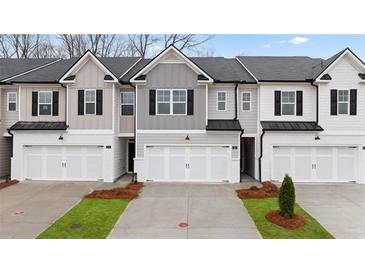 Charming new construction townhome featuring multiple units, brick accents, and manicured landscaping at 345 Sound Cir # 134, Stockbridge, GA 30281