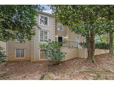 Two-story beige house with white trim, multiple windows, and a small front porch at 10 Braemore Dr, Sandy Springs, GA 30328