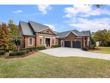 Brick home with a three-car garage and landscaped lawn at 6202 Talmadge Nw Way, Acworth, GA 30101