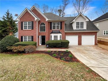 Charming two-story brick home with a well-manicured lawn and a two-car garage at 1615 Cheshire Ct, Lawrenceville, GA 30043