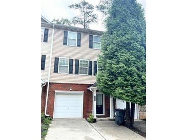 Two-story townhome with brick and siding exterior, attached garage, and landscaping at 650 Providence Sw Pl, Atlanta, GA 30331