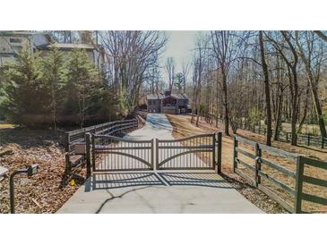 Long driveway leading to a modern home with a gated entrance at 600 Jones Rd, Roswell, GA 30075