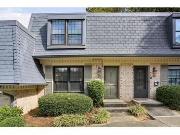 Charming townhome featuring a well-maintained yard and classic architectural details at 29 La Rue Nw Pl, Atlanta, GA 30327
