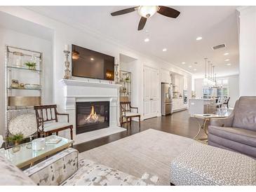 Bright living room showcasing a fireplace, dark wood floors, and open access to the kitchen at 2341 Brissett Ln, Brookhaven, GA 30319