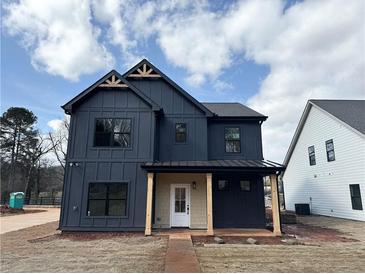 Striking two-story home showcasing navy siding, gabled roof, and a welcoming covered front porch at 42 Puckett Se Rd, Emerson, GA 30137