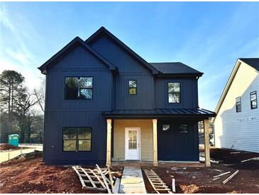 Two-story farmhouse with dark siding, light-colored accents, and a covered porch at 42 Puckett Se Rd, Emerson, GA 30137