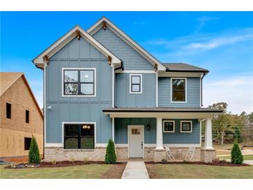 Charming two-story home with a welcoming front porch, blue siding, and white trim, set against a bright blue sky at 42 Puckett Se Rd, Emerson, GA 30137