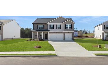 Charming two-story home with a manicured lawn and a two-car garage at 624 Kimberwick Dr, Locust Grove, GA 30248