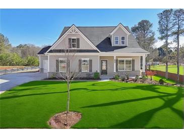 Two story house with gray siding, stone accents, and a lush lawn at 1461 Stephens View Dr, Loganville, GA 30052