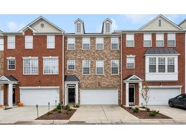 Brick front three-story townhome with attached garage and landscaping at 3819 Chattahoochee Summit Se Dr, Atlanta, GA 30339