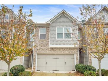 Charming townhome with brick and siding exterior, attached two-car garage and manicured landscaping at 4429 Newfangle Rd, Stone Mountain, GA 30083