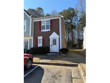 Brown siding townhouse with red shutters, white door, and small front yard at 6745 Trafalger Sq, Norcross, GA 30093